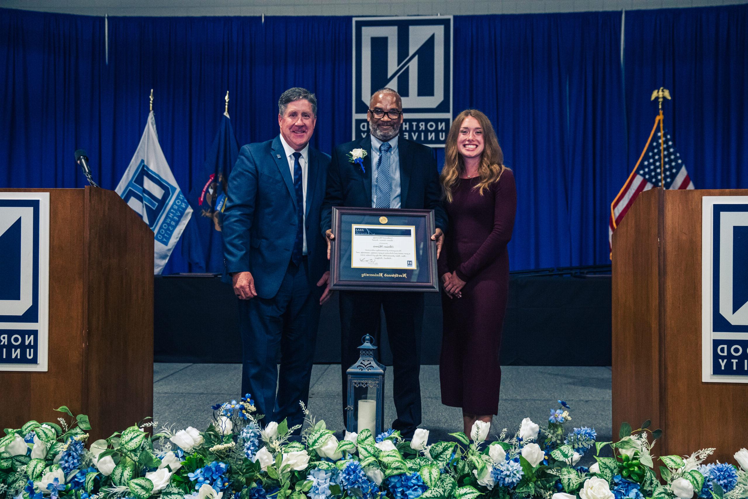 President Kent MacDonald standing with an alumni who was honored at the Outstanding Alumni Awards in 2023.